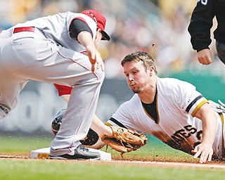 The Pirates’ Travis Snider is tagged out by Reds third baseman Todd Frazier while attempting to steal third during the first inning of Sunday’s game in Pittsburgh. Down 5-0 going into the seventh, the Pirates rallied to down the Reds, 10-7.