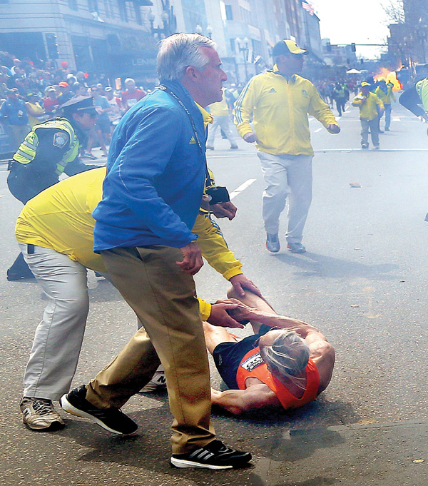 Volunteers react to a second explosion at the 2013 Boston Marathon on Monday. Medical personnel and public officials rushed to the aid of spectators, and the tent set up to care for fatigued runners was converted into a trauma clinic.