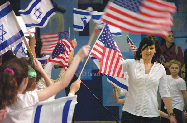 Talia Shlomi, a teacher at Akiva Academy, leads students during the opening ceremony Sunday of The Israel 65 Celebration at the Jewish Community Center in Youngstown. The event featured Israeli music, food, games and crafts.