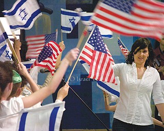 Talia Shlomi, a teacher at Akiva Academy, leads students during the opening ceremony Sunday of The Israel 65 Celebration at the Jewish Community Center in Youngstown. The event featured Israeli music, food, games and crafts.