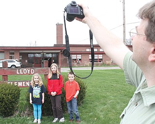 William Harris takes a photo of his niece Emily Orlaski, a second-grader at Lloyd Elementary in Austintown, daughter Hannah Harris, a sixth-grader who attended Lloyd, and son Matthew Harris, a third-grader at Lloyd. An open house took place Wednesday for students, teachers and alumni to gather and say farewell to their school.