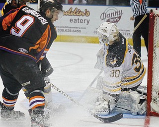 Austin Cangelosi (9) of the Youngstown Phantoms make an attempt on the goal which is defended by Green Bay goalie Tony Kujava (30) and defensman Jake Linhart (88) during Game 4 of their first-round USHL Clark Cup playoff series Sunday at the Covelli Centre in Youngstown. The Phantoms, who led the series 2-1 going into Sunday’s contest, ousted the defending league champion Gamblers, 3-1, with Cam Brown netting the game-winning goal with 5:52 remaining in the third period and teammate Alexander Dahl adding an empty-net goal for insurance.