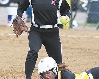 Bristol’s Megan Adams dives back to first base ahead of a tag by Mathews Tabby Granelly (25) during a pick-off attempt in Thursday’s softball game at Mathews High School. The Mustangs rallied to down the Panthers, 5-3, in 10 innings.