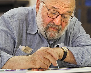 Mordechai Rosenstein concentrates on starting a painting focusing on Israel and related elements during an open house Thursday at Temple El Emeth in Liberty. The artist uses the Hebrew alphabet as his inspiration, incorporating bright colors and various shapes to convey a theme.