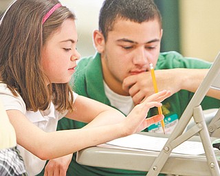 Natalie Femia, a third-grader at St. Christine School, and Donte Velazquez, a sophomore at Ursuline High School, work on a word game Thursday at Ursuline. Sophomores there corresponded throughout the school year with third-graders from St. Patrick, St. Christine, St. Rose and St. Joseph/Immaculate Heart of Mary schools. The students met Thursday.