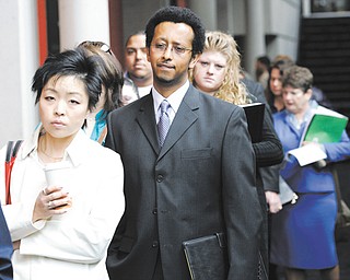 Job-seekers, including Sophonias Gizaw, center, of Seattle, wait in line to attend a job fair in Tacoma, Wash. Gizaw said he was looking for work in banking, finance, or the insurance industry. Now, in 2013, four years after the financial crisis, a more-cautious banking sector is cutting tens of thousands of jobs.