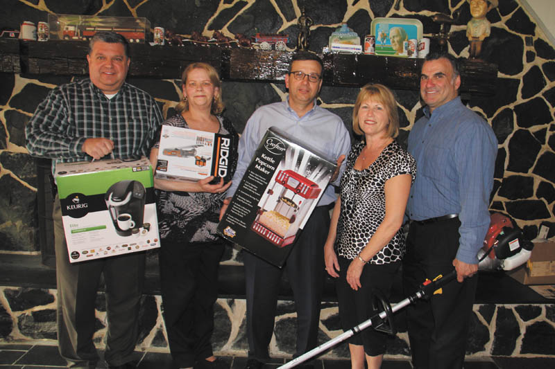 DUSTIN LIVESAY | THE VINDICATOR
Officials of the Strimbu Memorial Fund, from left to right, Dennis Lieb of Sharon, Pa., treasurer; Connie Schenker of Sharpsville, Pa., assistant to the board; Jim Grasso of Sharon, vice president; Nancy Lukasko of Brookfield, board member; and Bernie Carpenter of Brookfield, board member, hold items that will be auctioned at the 24th annual Strimbu Memorial Barbecue on May 8 in Brookfield. 