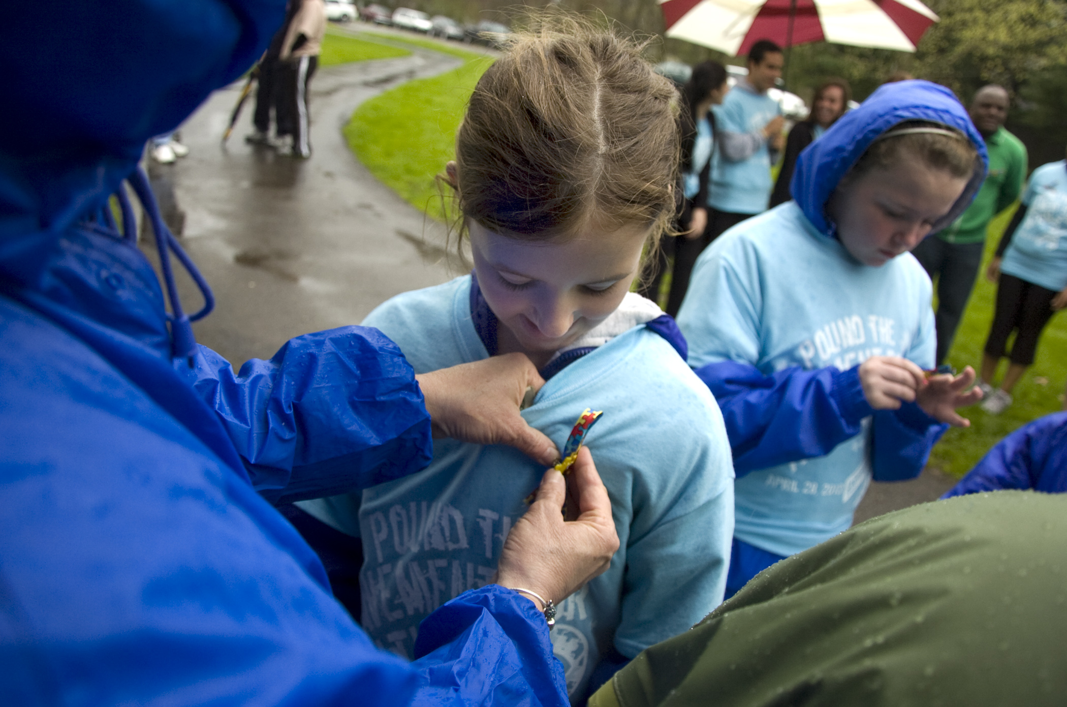 Kelli Cardinal/The Vindicator
Samantha Burnbrier, 9, of Poland, watches Teena (ok) Kovach, of Howland, pin an Autism awareness ribbon to her t-shirt Sunday before the Pound the Pavement for Autism walk in Howland Township Park.