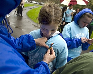 Kelli Cardinal/The Vindicator
Samantha Burnbrier, 9, of Poland, watches Teena (ok) Kovach, of Howland, pin an Autism awareness ribbon to her t-shirt Sunday before the Pound the Pavement for Autism walk in Howland Township Park.