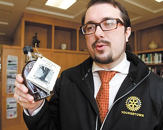 John Slanina, president of the Rocky Ridge Neighborhood Association, holds a bottle of Mill Creek pure maple syrup, gathered from sugar maples near Wick Recreation Area. The RRNA and Mill Creek MetroParks are selling the 300 bottles, with proceeds to be used for a playground in the recreation area and for neighborhood improvements.
