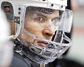 Pittsburgh Penguins’ Sidney Crosby sits on the bench watching a power play drill during hockey practice in Canonsburg, Pa., Tuesday. Crosby has not been cleared to return to action since being hit in the face with a puck.