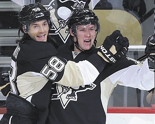 The Penguins’ Kris Letang (58) congratulates Beau Bennett after Bennett scores a goal against the New York Islanders in the first period of Game 1 of their NHL Stanley Cup Eastern Conference playoff series Wednesday
in Pittsburgh. Letang also scored for the Penguins who blanked the Isles, 5-0.
