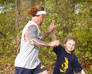 MADELYN P. HASTINGS | THE VINDICATOR
(L-R) Gregg Genovese high fives his daughter Madelyn Genovese, 6, of Streetsboro just before he crosses the finish line in 2nd place at the 1st annual Tails on Trails 5K walk at Austintown Township Park. All proceeds benefit Friends of Fido Mahoning County Dog Pound.