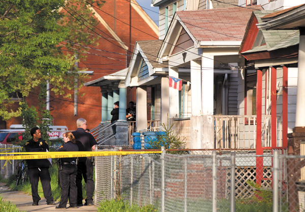 Cleveland police stand outside a home where they say Amanda Berry, Gina DeJesus and Michele Knight, who went missing separately about a decade ago, were found in the 2200 block of Seymour Avenue on Monday.