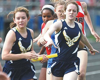 McDonald’s Bailee D’Amore, left, takes the baton from her sister Abby D’Amore in the 4x800 relay on Tuesday during the first day of the Trumbull County Track and Field Meet at Lakeview High School.