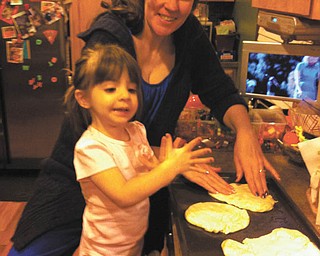 Angela and Sophia Testa are having fun making pizza.
