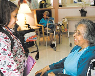 Amaryllis Rivera, a third-grader at Martin Luther King Elementary School, gives a Mother’s Day card to Metlean Singleton, a resident at Danridge Burgundi Manor nursing home on Youngstown’s East Side. The schoolchildren also sang songs and read poems Thursday.