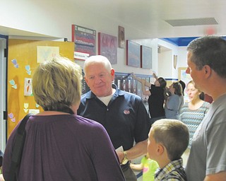 Dr. Tom Stellers, center, talks to attendees at Woodside Elementary School’s farewell open house Thursday in Austintown. Stellers, now a member of the Austintown Board of Education, was a student when the school opened in the late 1940s.