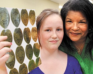 Delphine Baldwin-Casey, right, a retired Youngstown police officer and commander of the Black Knights Police Association Youth Police Academy, poses next to Skyann Braun, a sixth-grader at Volney Rogers Academy, a middle school on Youngstown’s West Side. Skyann was one of several graduates honored Monday for completing an academy program. She also earned the highest number of badge stickers during the program.