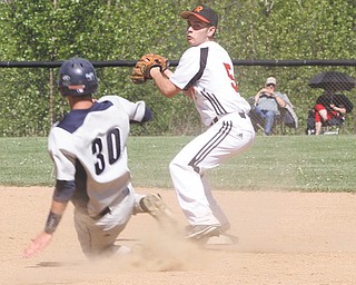 McDonald’s Christian Rusinowski (30) tries to keep Mineral Ridge’s Nick Ferguson from making the double play at first during their Division IV sectional final Thursday in McDonald. The Blue Devils ousted the Rams, 16-2.
