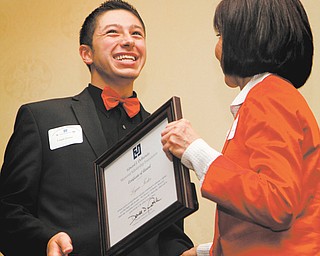 Denise DeBartolo York presents Logan Foster from East Palestine High School with a plaque marking his receipt of a scholarship from the Edward J. DeBartolo Memorial Scholarship Fellowship. Eight students received the scholarships totaling $56,000 at a Thursday luncheon at the Holiday Inn in Boardman.