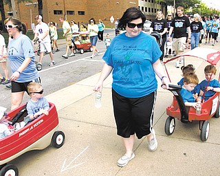 Kelly Robertson of New Middletown walks and pulls a wagon Sunday with her triplets, Mathew, Michael and Morgan, during the March of Dimes March for Babies that started at the WATTS Center at Youngstown State University. Robertson’s children were born at 29 weeks.