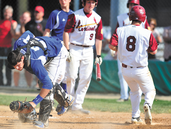 Poland catcher Nick Andrews, left, reacts after Cardinal Mooney’s Drew Wollet (8) scored on an error during a Division II district semifinal Monday at Cene Park in Struthers. The Cardinals edged the Bulldogs, 9-8.