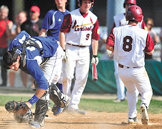 Poland catcher Nick Andrews, left, reacts after Cardinal Mooney’s Drew Wollet (8) scored on an error during a Division II district semifinal Monday at Cene Park in Struthers. The Cardinals edged the Bulldogs, 9-8.