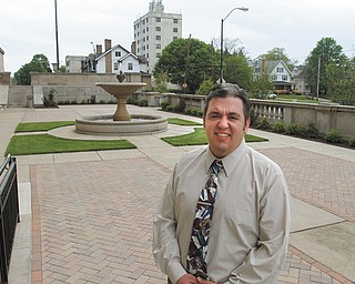 Chris Lewis, director of marketing and public relations at Stambaugh Auditorium, stands in the newly renovated formal garden space. Overgrown trees were removed to open up the area, available to rent for small events. Brick pavers were added. This summer, the space will be used for weekday concerts.