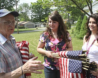 William D. Lewis\The Vindicator
Meter Fromel, 85 and a Marine Corp vet passes out flags to Austintotwn Fitch NHS members Lynnette Seebacher,left, and LAura Wilson. The flags will be placed along 2 street sin Fromels Austintown neighborhood.