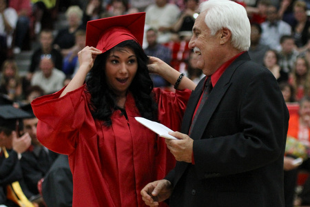 .IMG 9284: ÊAlicia Leone catches her cap before it falls off while receiving her diploma from Board of Education president Ron CarcelliÊduring commencement at the Struthers Field House on Sunday. ÊDustin Livesay Ê| ÊThe Vindicator Ê5/26/13 ÊStruthers High School. Ê