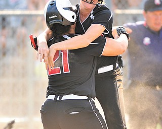 Mathews’ Jacki Rhine (21) hugs teammate Jessica Marsico after Marsico scored the game-winning run in their Division IV regional softball semifinal against Cuyahoga Heights on Wednesday at Kent State University. The Mustangs downed the Redskins, 1-0.