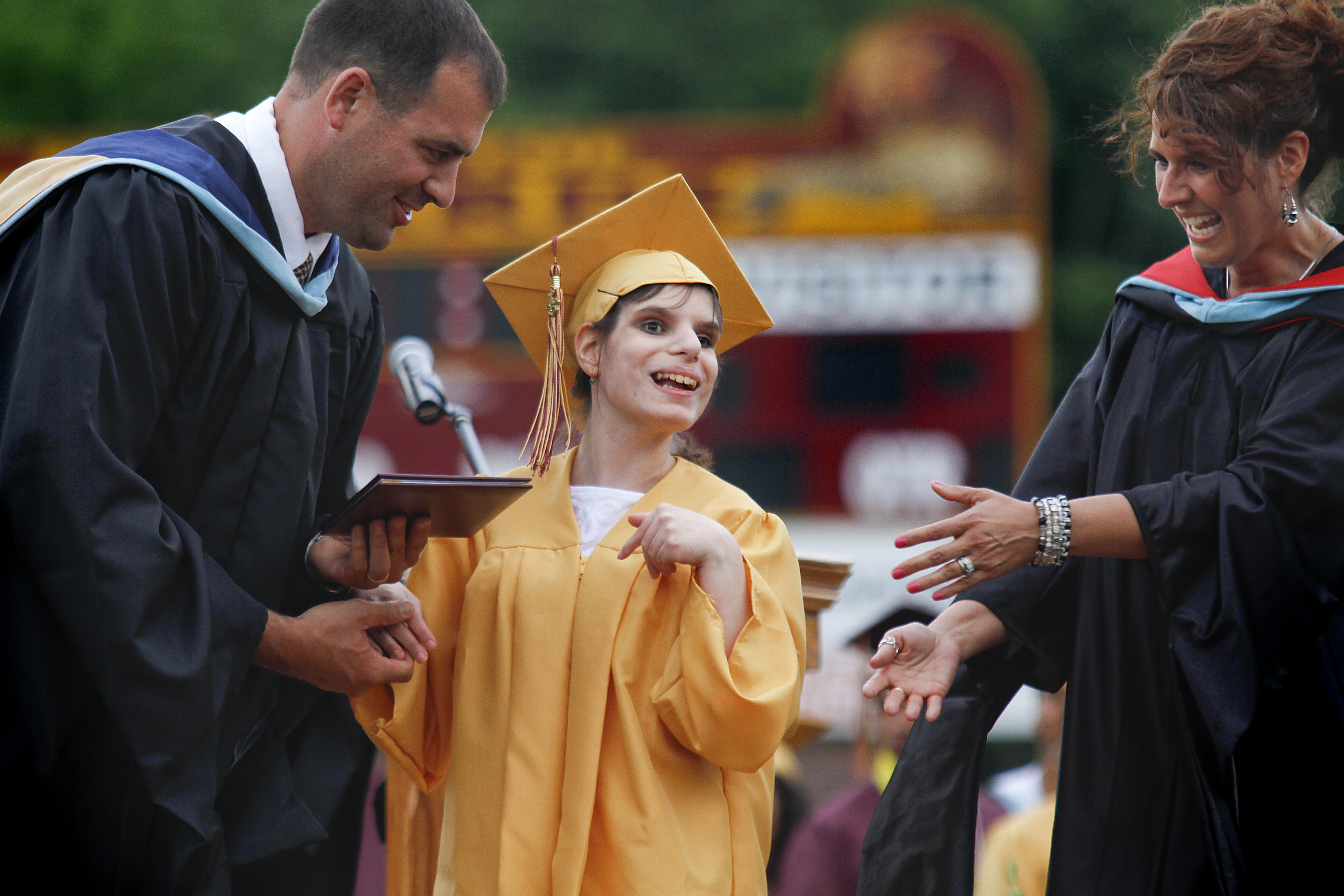 MADELYN P. HASTINGS | THE VINDICATOR

David Malone and Michele Stewart present a diploma to Paige Goodman (center) as she walks across the stage during Liberty High School's commencement.
