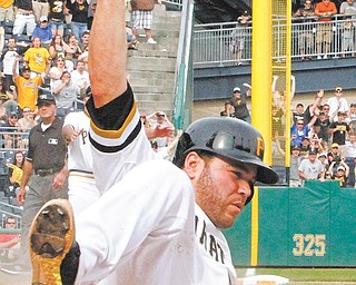 Pittsburgh Pirates’ Russell Martin scores the game winning run on an 11th-inning single by the Pirates’ Travis Snider off Cincinnati Reds relief pitcher Alfredo Simon to end the game in Pittsburgh on Sunday.