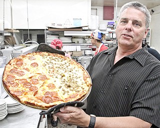 Jack Walter, Elmton owner, shows a pizza at his Struthers eatery.