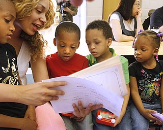 Mom Tabitha Bonner and Harding Elementary kindergarten graduate Paul Bonner, left, show his “Kindergarten Memories” book to siblings Deyor, 5; Norlynn, 4; and Layla, 3. The kids wrote and illustrated books throughout the year and shared them with loved ones Tuesday at a breakfast tea.