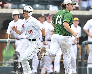 Ursuline pitcher Sam Donko 313 looks to left field after allowing a hit while Wheelersburg baserunner #26 Wade Martin heads home to score the first run of the game on the top of the 8th. 