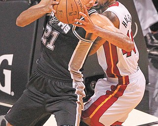 The Spurs’ Tim Duncan (21) drives against the Heat’s Udonis Haslem during the first quarter of Game 1 of the NBA Finals on Thursday at American Airlines Arena in Miami. Duncan scored 20 points for San Antonio, which won 92-88.