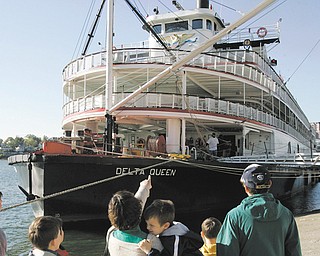 A family views the riverboat Delta Queen as it is docked on the public landing on the Ohio River in Cincinnati. Some Ohioans in Congress say proposed legislation allowing the Delta Queen steamboat to again carry passengers on overnight trips on America’s rivers could help bring the historic vessel back to Ohio.