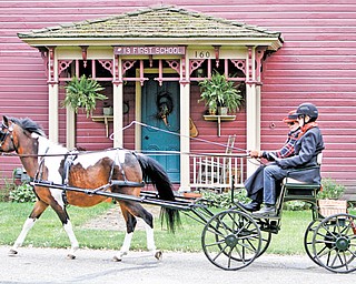 Janet Yosay and Pat Moore of Canfield drive a bird-in-hand Eagle carriage pulled by “Scout,” a paint/Welsh cross pony in front of the Old School House in Zoar. It was built in 1836. Zoar is about 80 miles southwest of Youngstown.