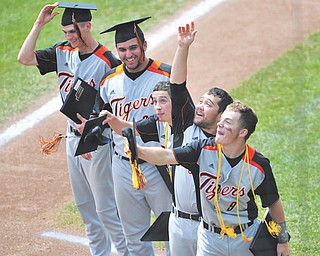 Springfield’s five senior players, from left, Chris Bishard, Dom Gentsy, JoJo Carabello, Cody Pitzo and Eoghan Bees toss their graduation caps into the air after receiving their diplomas near home plate at Huntington Park in Columbus before the start of Sunday’s Division IV state baseball final against Newark Catholic.