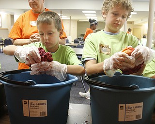 ROBERT K. YOSAY | THE VINDICATOR
messy dips - as Aidan Kolenich 6 and Kohl Fizet (ok) wring out the shirts after dipping them in die !
the Downtown Mission’s Children’s Art Camp, currently under way at St. Columba Cathedral parish hall about 25 participants enjoy the activities.