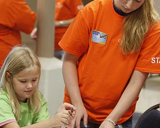 ROBERT K. YOSAY | THE VINDICATOR
Ami (ok) Scanina 9, starts turning the fork in her shirt to get it ready for a tie die shirt for camp - with her is advisor Isabel Stoeber
the Downtown Mission’s Children’s Art Camp, currently under way at St. Columba Cathedral parish hall about 25 participants enjoy the activities.