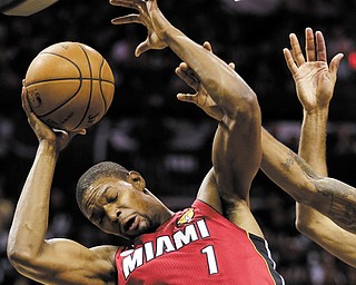Miami’s Chris Bosh (1) grimaces as he tries to find some space under the basket during the first half of Tuesday’s NBA Finals game in San Antonio, Texas.