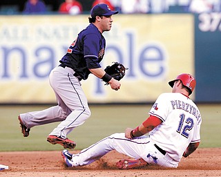 Cleveland Indians second baseman Jason Kipnis (22) jumps as Rangers baserunner A.J. Pierzynski (12) slides into second base on the double play during the third inning of Tuesday’s game in Arlington, Texas. Nelson Cruz was out at first.