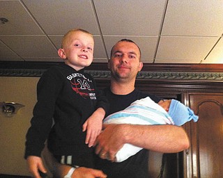 Kevin Cibula of Leetonia is holding his 5-year-old son, Ethan, and his other son, Jase, who was just born on Mothers Day.