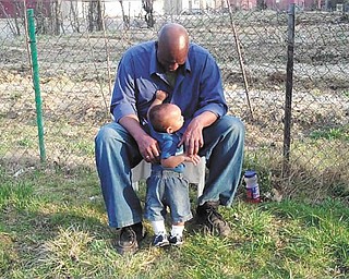 Frankie Bellamy and Franklin III, are in front of the family garden before Planting Season 2013.