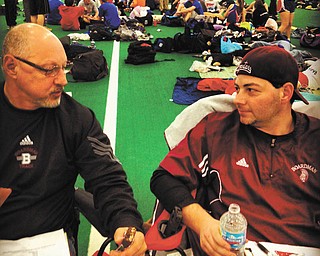 Pictured are two generations of Spartan coaches: John R. Phillips, head boys track and cross-country coach, is discussing strategy at an indoor meet in January at Kent State University with his father and assistant coach, John F. Phillips.