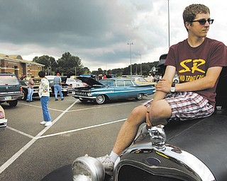 Anthony Marsilio, 16, a South Range High School junior, sits on the hood of his 1929 Ford during the Ninth Annual Father’s Day Car Show at South Range High School. Marsilio was showing the car with his father, Hank, who taught him how to drive vintage vehicles.