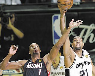 The Heat’s Chris Bosh (1) and the Spurs’ Tim Duncan (21) battle for the ball during Sunday’s Game 5 of the NBA Finals in San Antonio.